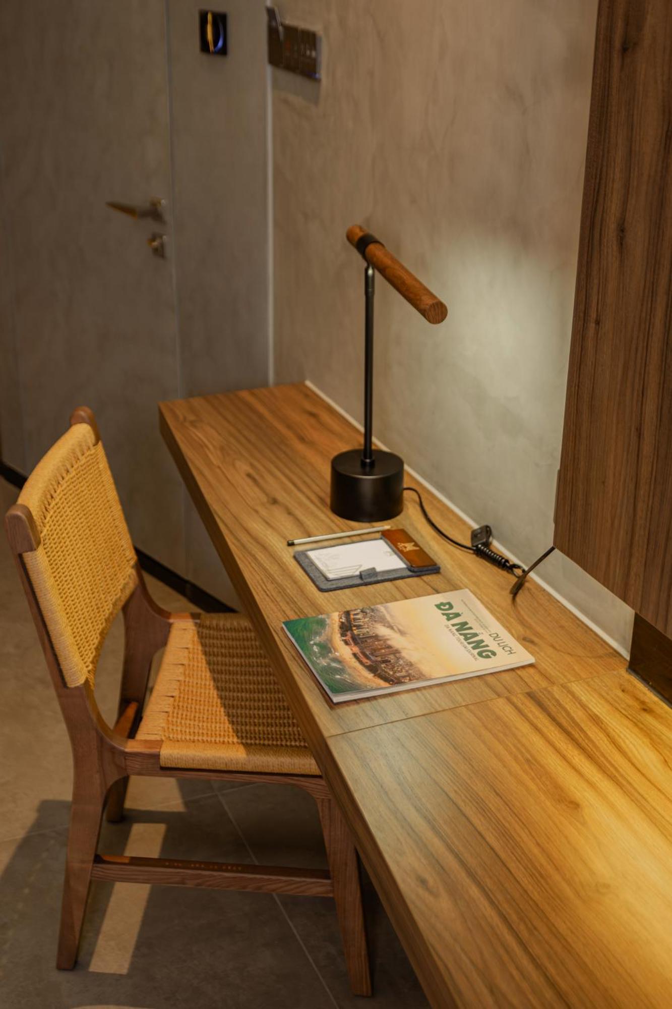 M Hotel Danang Exterior photo A desk with a magazine on it